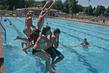 Group of kids jumping into pool together