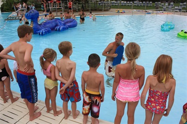 Kids watching instructor poolside