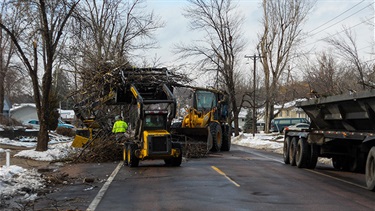 Snow plows clearing branches from april ice storm in 2013