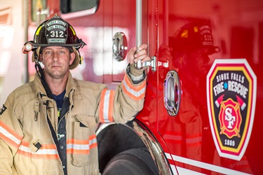 firefighter next to firetruck