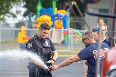 Police officer using a fire hose
