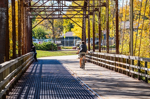 A cyclist rides over the Cherry Creek bridge on the Sioux Falls recreation trail