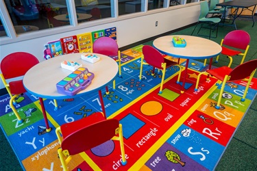 Tables of different toys in the toddler zone