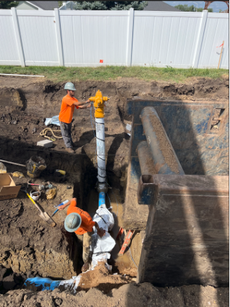 Contractor installing a fire hydrant along 12th Street.