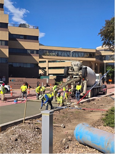 Workers laying cement and screening finishes