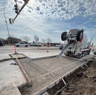 A cement truck pouring new concrete in a repair section.