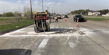A skid-loader breaking up concrete that needs repair.
