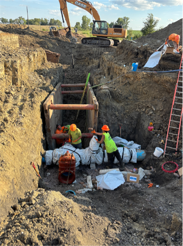 Contractor installing the 16” watermain cross under 476th Avenue. 