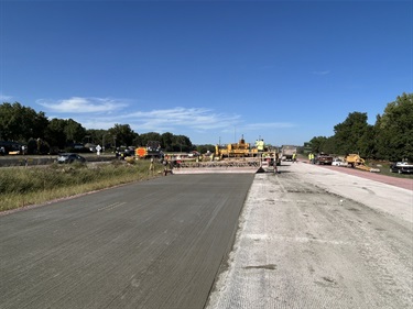 Crews smoothing new concrete and texturizing