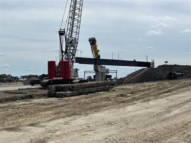 two cranes installing a bridge girder