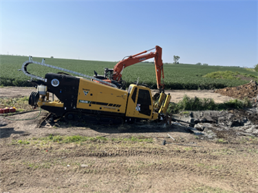Machine at the east end of the boring under the creek that will pull the drill head and waterpipe through the boring. 