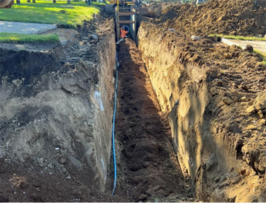 Contractor backfilling the watermain pipe trench on the south side of Highway 42/12th Street.