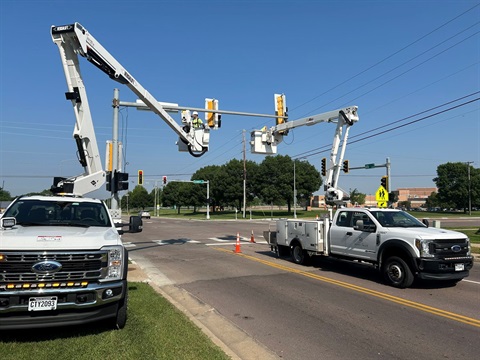 an image of boom trucks installing traffic signals