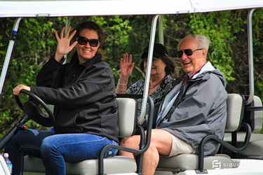 parks employee waving on a golf cart