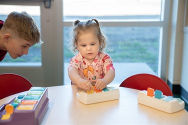 a little girl playing at a sensory table