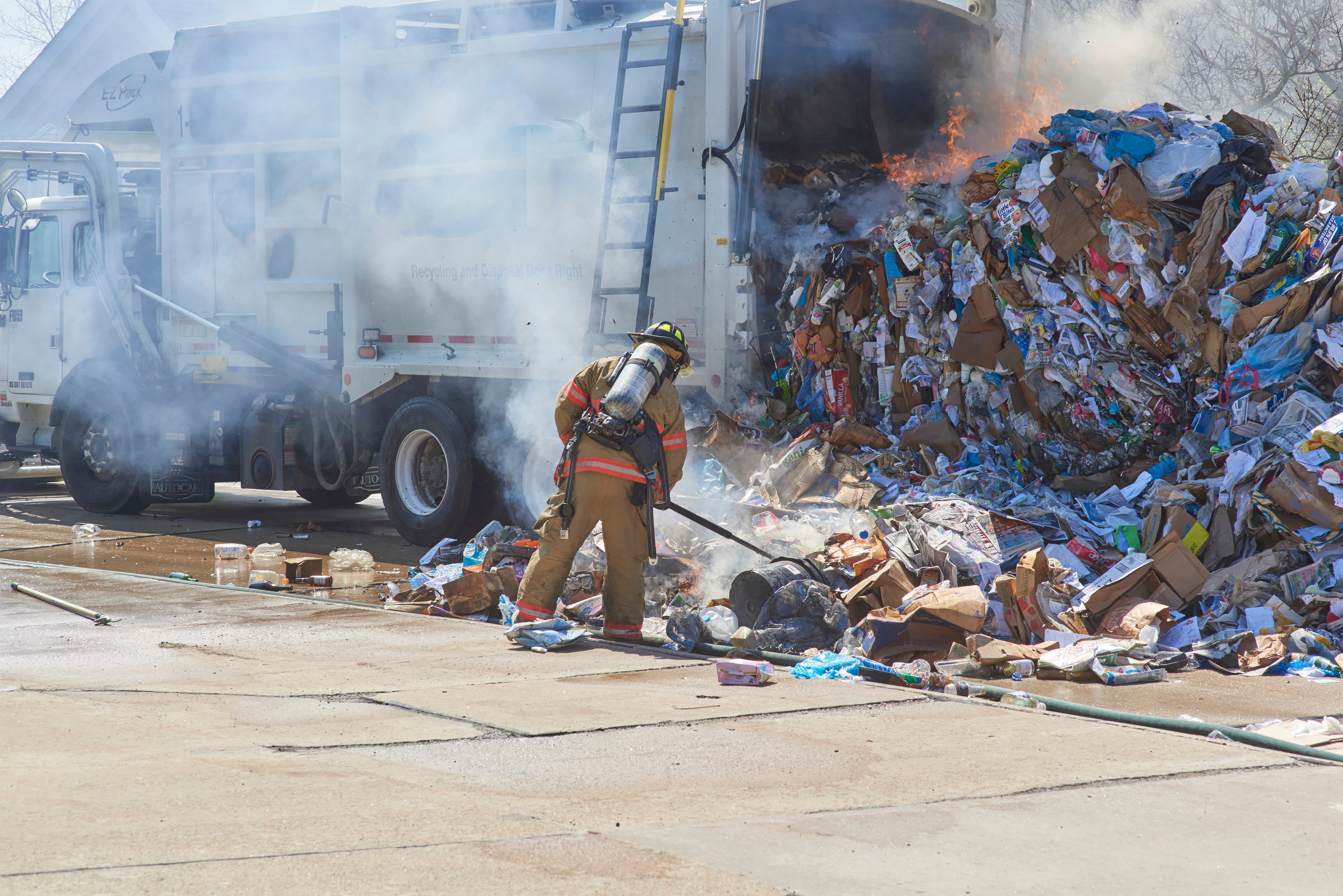 Firefighter sifting through trash fire